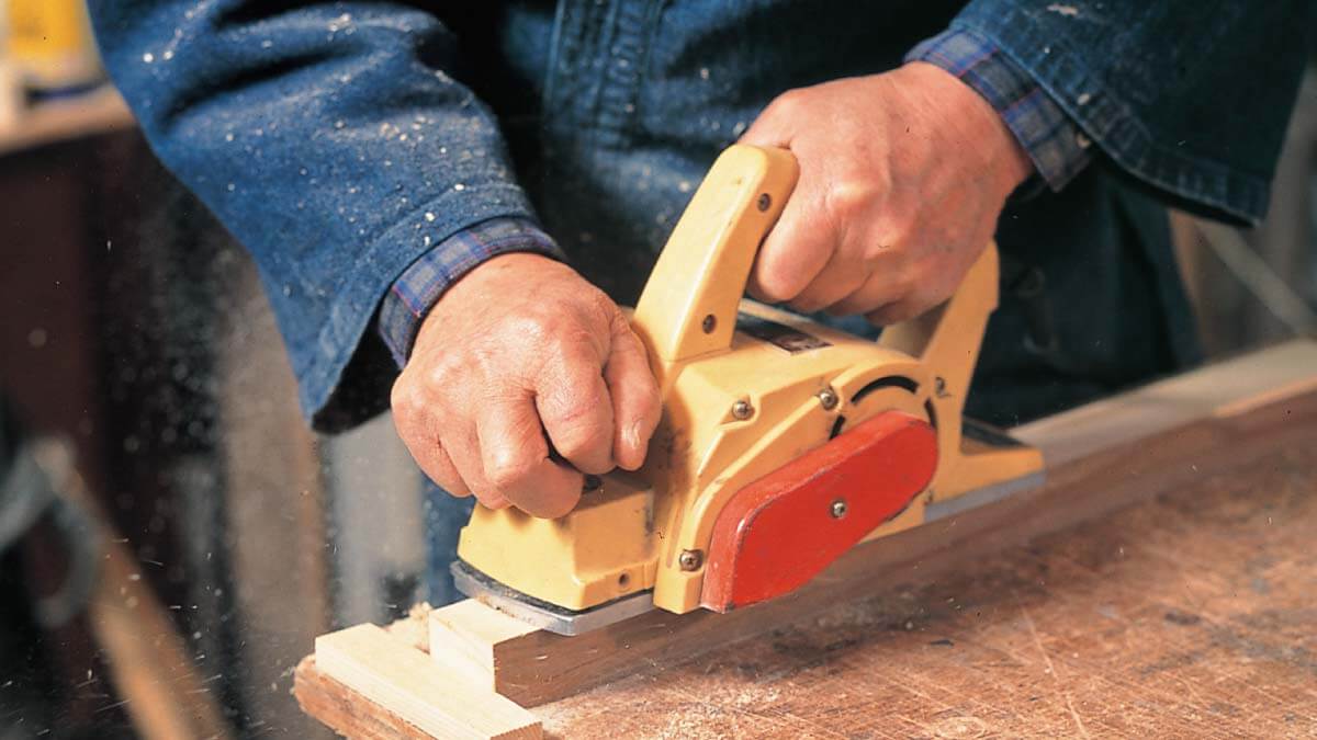 電動ヤスリで木材を加工する手元